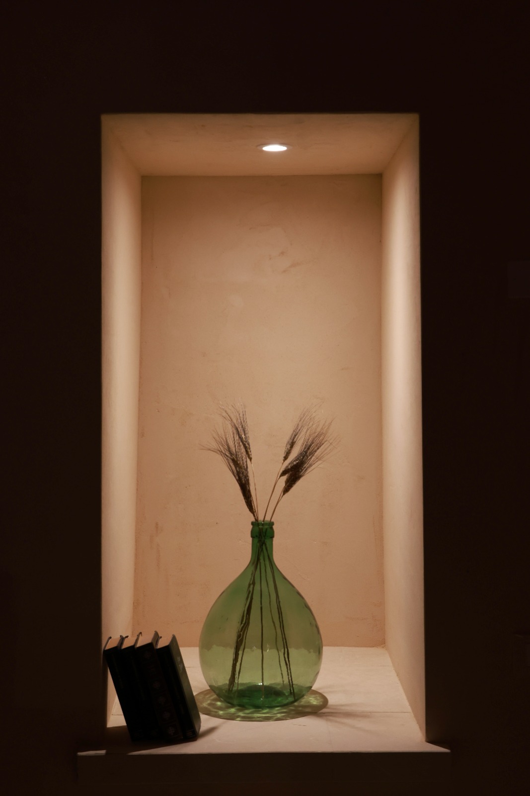 Nicchia illuminata con damigiana verde