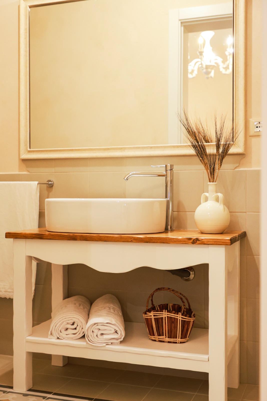 Lavabo con specchio e lampadario riflesso