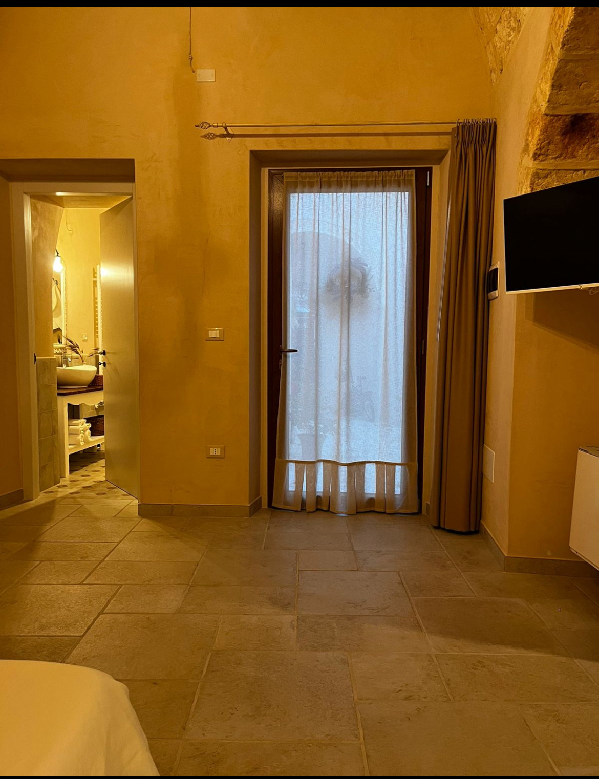 Finestra con tende e vista sul bagno
