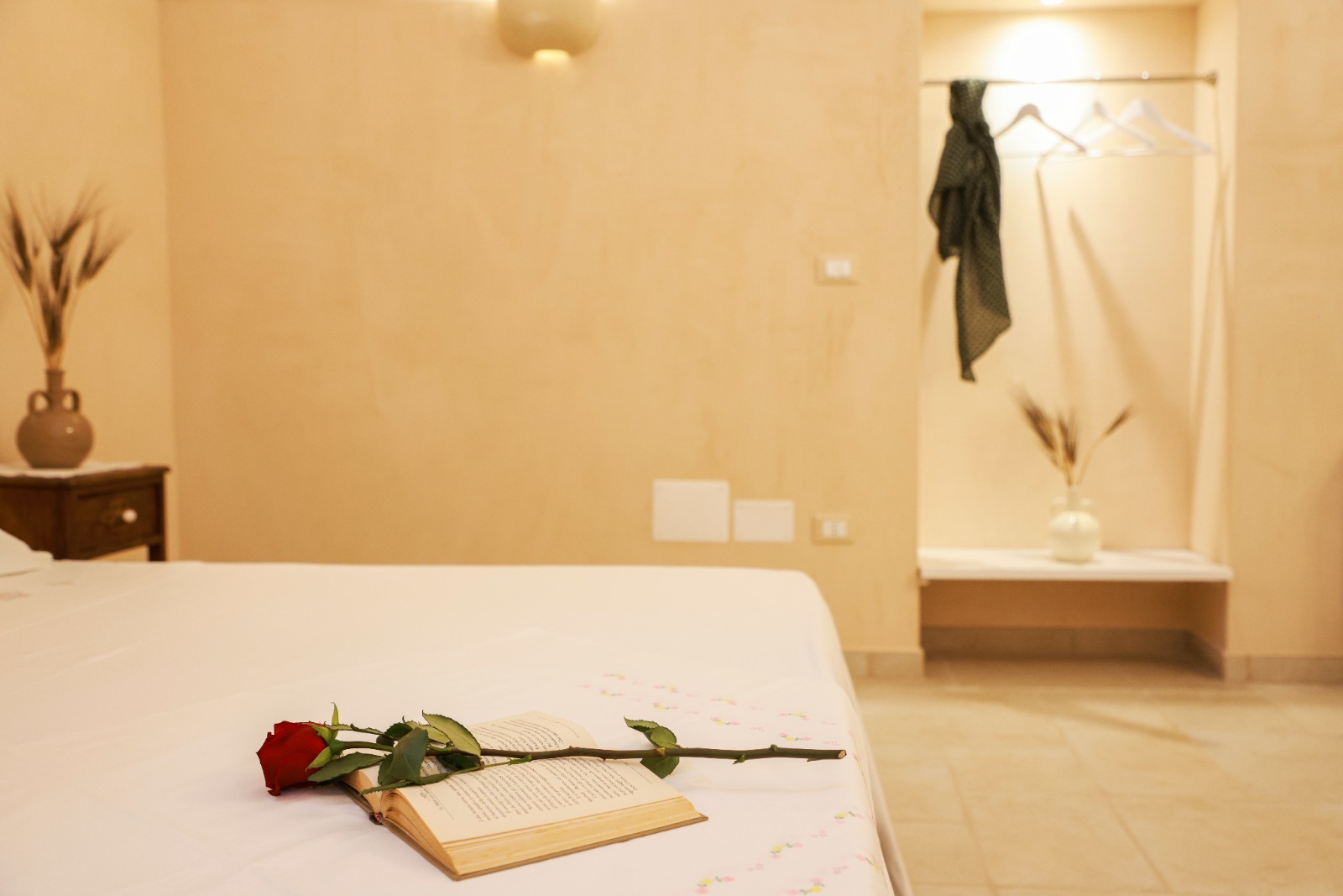 Rosa rossa e libro aperto sul letto